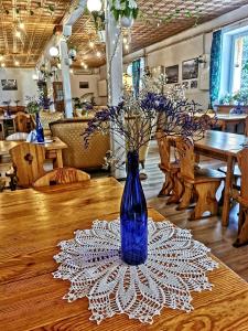 un vaso blu seduto sopra un tavolo di "Aleksandrówka" Restauracja i Noclegi a Horyniec