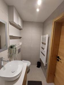 bagno con lavandino bianco e servizi igienici di Casa Gray a Capodistria