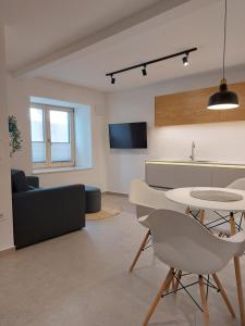 a living room with a couch and a table and chairs at Casa Gray in Koper