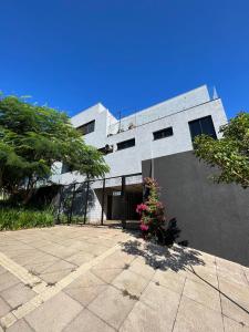 a white building with a courtyard in front of it at Estúdio Central 3 in Cascavel