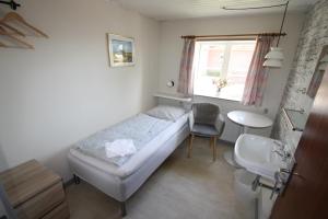 a small bedroom with a bed and a sink at Hostel Rudbøl in Rudbøl