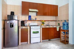 een kleine keuken met een koelkast en een fornuis bij Orquideas Villas & Studios at Country House in Cancun