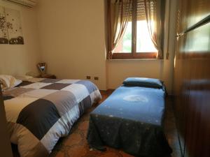 1 Schlafzimmer mit 2 Betten und einem Fenster in der Unterkunft Casa Poggio in Cagliari