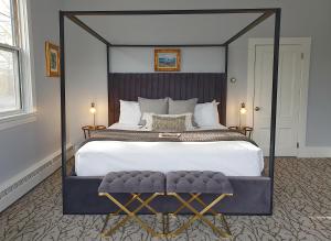 a bedroom with a large bed with a black frame at Little Fig Hotel in Bar Harbor