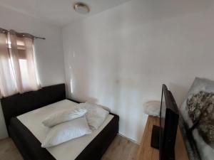 een slaapkamer met een bed met 2 kussens erop bij Mely Apartment in Krk