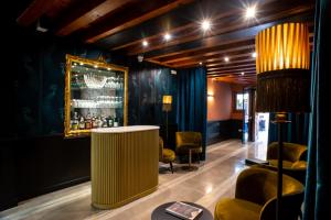 a lobby with a bar with chairs and a table at Palazzina Fortuny in Venice
