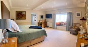 a bedroom with a bed and a chair and a window at Old Hall Cressage in Shrewsbury