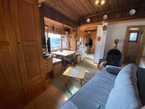 ein Wohnzimmer mit einem Sofa, einem Tisch und einem Schreibtisch in der Unterkunft Hexenhäusl in Mittenwald