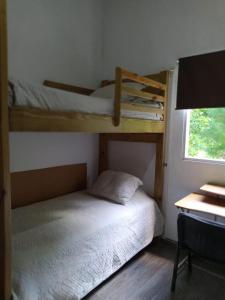 a bedroom with two bunk beds and a desk at Chalet los Pinos Constanza in Arroyo Frío +51 photos