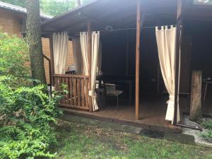 a screened in porch with curtains and a table at PRZY KWADRACIE in Boszkowo