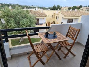 - Balcón con mesa pequeña y 2 sillas en Rosamar, en Alvor