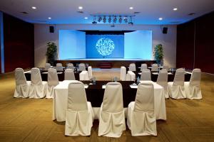 einen Konferenzraum mit einem Tisch, Stühlen und einer Bühne in der Unterkunft The Reef Coco Beach Resort & Spa- Optional All Inclusive in Playa del Carmen