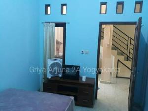 um quarto com uma cama, um espelho e uma escada em Griya Arjuna 2A em Ngabean