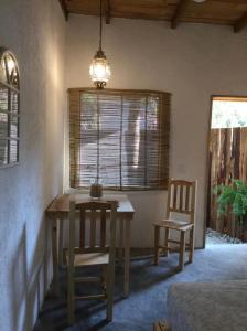 Casa de Kai Mazunte في مازونتي: غرفة طعام مع طاولة وكرسيين