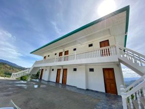 a large white building with a balcony at JR RESORT in Ranau