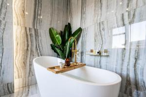 a bathroom with a white tub with a plant on it at Serenity Prague Villa with garden jacuzzi in Prague