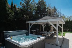 uma banheira de hidromassagem com um gazebo num quintal em Serenity Prague Villa with garden jacuzzi em Praga