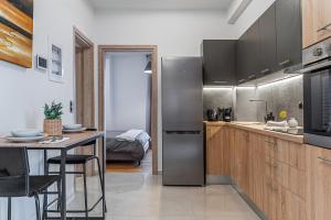 a kitchen with a stainless steel refrigerator and a table at Athena Studio in Gazi in Athens