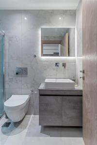 a bathroom with a sink and a toilet and a mirror at Athena Studio in Gazi in Athens +12 photos