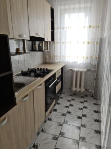 a kitchen with a black and white tiled floor at Apartament Mario Forty in Mangalia