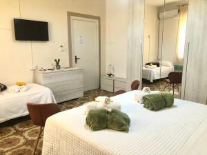 una camera d'albergo con due letti e una televisione di City B&B a Castelsardo