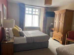 1 dormitorio con cama y ventana en The Lantern Townhouse en Dingle