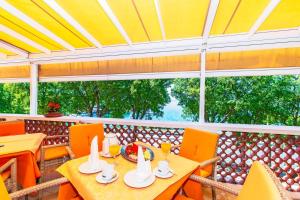 comedor con mesa, sillas y ventana en Rooms and Restaurant Danica en Povile