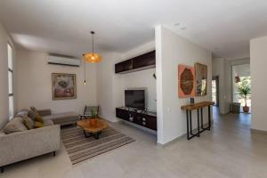 ein Wohnzimmer mit einem Sofa und einem TV in der Unterkunft Villa Venus in Playa Santa Teresa