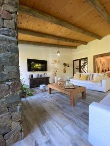 a living room with a table and a stone wall at CASA MIA bednbreakfast in Colonia del Sacramento