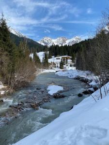a river with snow and mountains in the background at Groot appartement in Aparthotel met prachtig uitzicht in Mittelberg