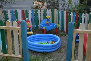 um equipamento de brincar para crianças em frente a uma cerca em Gaia Hotel Olimpos em Kumluca