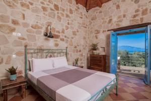 a bedroom with a bed and a stone wall at Strofilia Stone Residences in Volimes