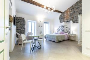 een slaapkamer met een bed en een tafel en stoelen bij Casa Contrada Bella in Varenna