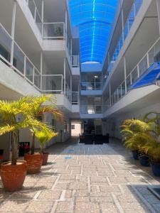 an empty hallway with palm trees in a building at Caribbean Island Hotel in San Andrés