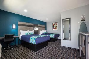 a hotel room with two beds and a mirror at Knights Inn & Suites Salem in Salem