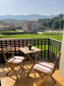 a wooden table and two chairs sitting on a balcony at Camino al Cuera in Llanes