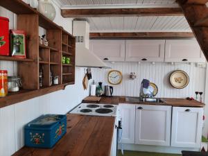 a kitchen with white cabinets and a stove top oven at Lovisenborg Brygge in Kongsfjord