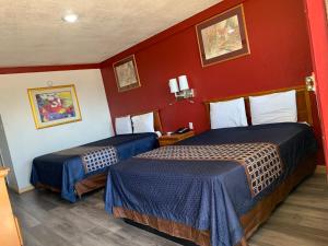 two beds in a hotel room with red walls at Budget Inn in Memphis