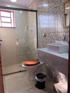 a bathroom with a toilet and a sink at Pousada Recanto das Flores in Aiuruoca