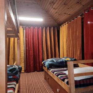 Shangarh的住宿－Mud Hostel Shangarh，客房设有两张双层床和窗帘。