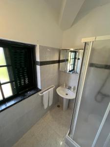 
a bathroom with a shower, sink, and mirror at Silver Coast Vacation Inn in Lourinhã

