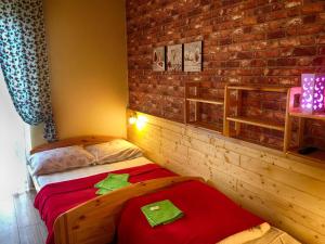 Dom Wypoczynkowy ADRIA في كرينيتسا زدروي: غرفة نوم بها سريرين وجدار من الطوب +27 صورة