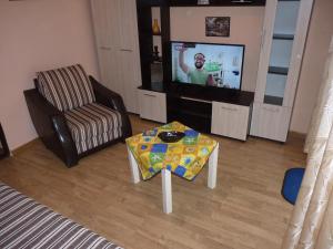 ソゾポルにあるАпартамент Хармонияのリビングルーム(テレビ、テーブル、椅子付)