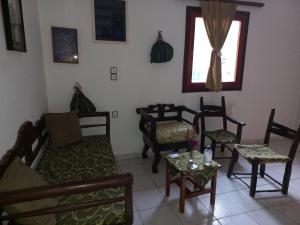 salon z krzesłami, kanapą i oknem w obiekcie Castro Kerame w mieście Kerames