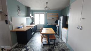 a kitchen with blue walls and a table in it at LE JADE in Saint-Nazaire