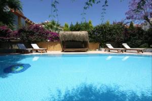 a large swimming pool with chairs and a bale at Villa Sophia Marmaris in Marmaris