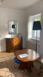 een woonkamer met een tafel en een spiegel bij Schlossapartments Wolfsberg in Wolfsberg
