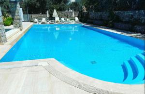 a large swimming pool with blue water at Olivia Apartment at Ölüdeniz - Central in Oludeniz