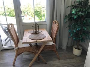 una mesa de madera con 2 sillas y una lámpara. en Luxe prive-kamer - studio in villa aan zee, Dishoek, vernieuwd, en Dishoek