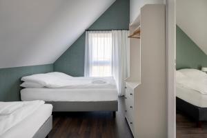 sypialnia z 2 łóżkami i oknem w obiekcie W Starym Porcie w mieście Krynica Morska